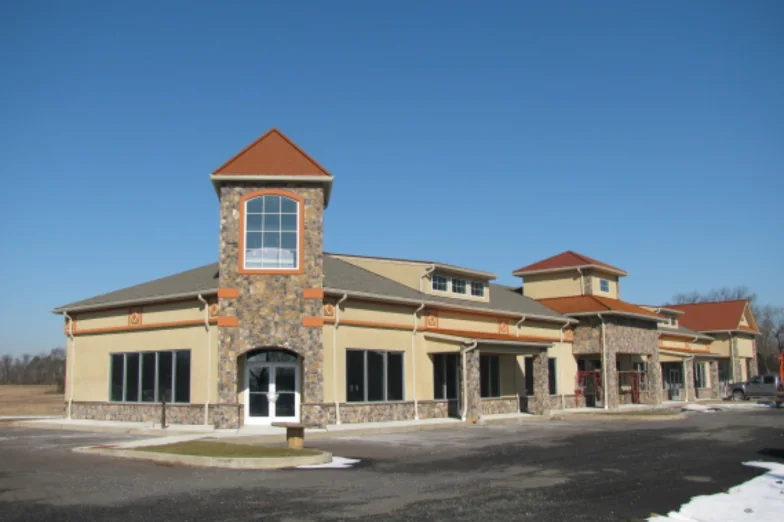 Retail building with a stone entry tower and copper-roofed cupolas